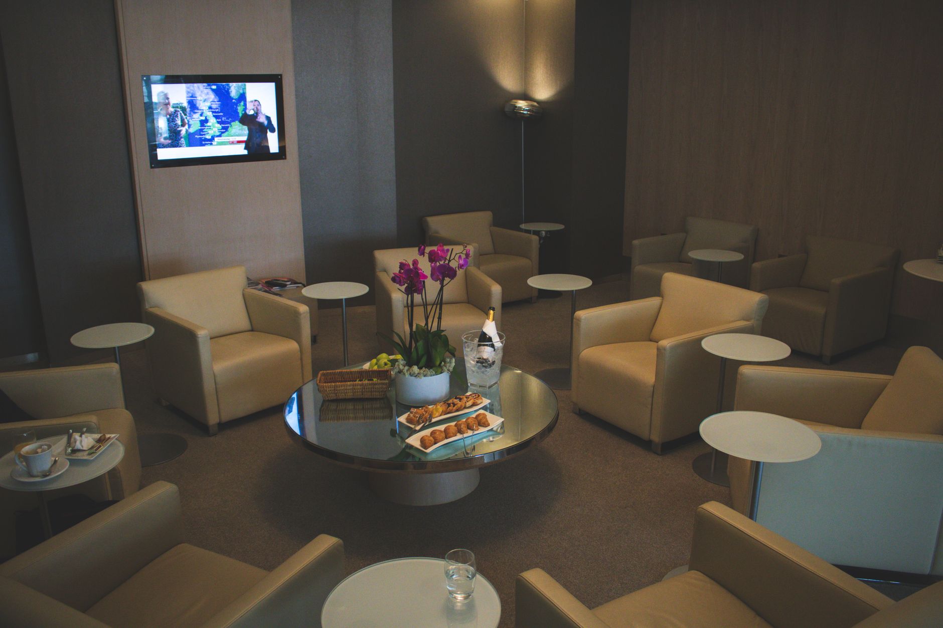 Airport lounge interior with cream leather armchairs, low tables and pastries laid out