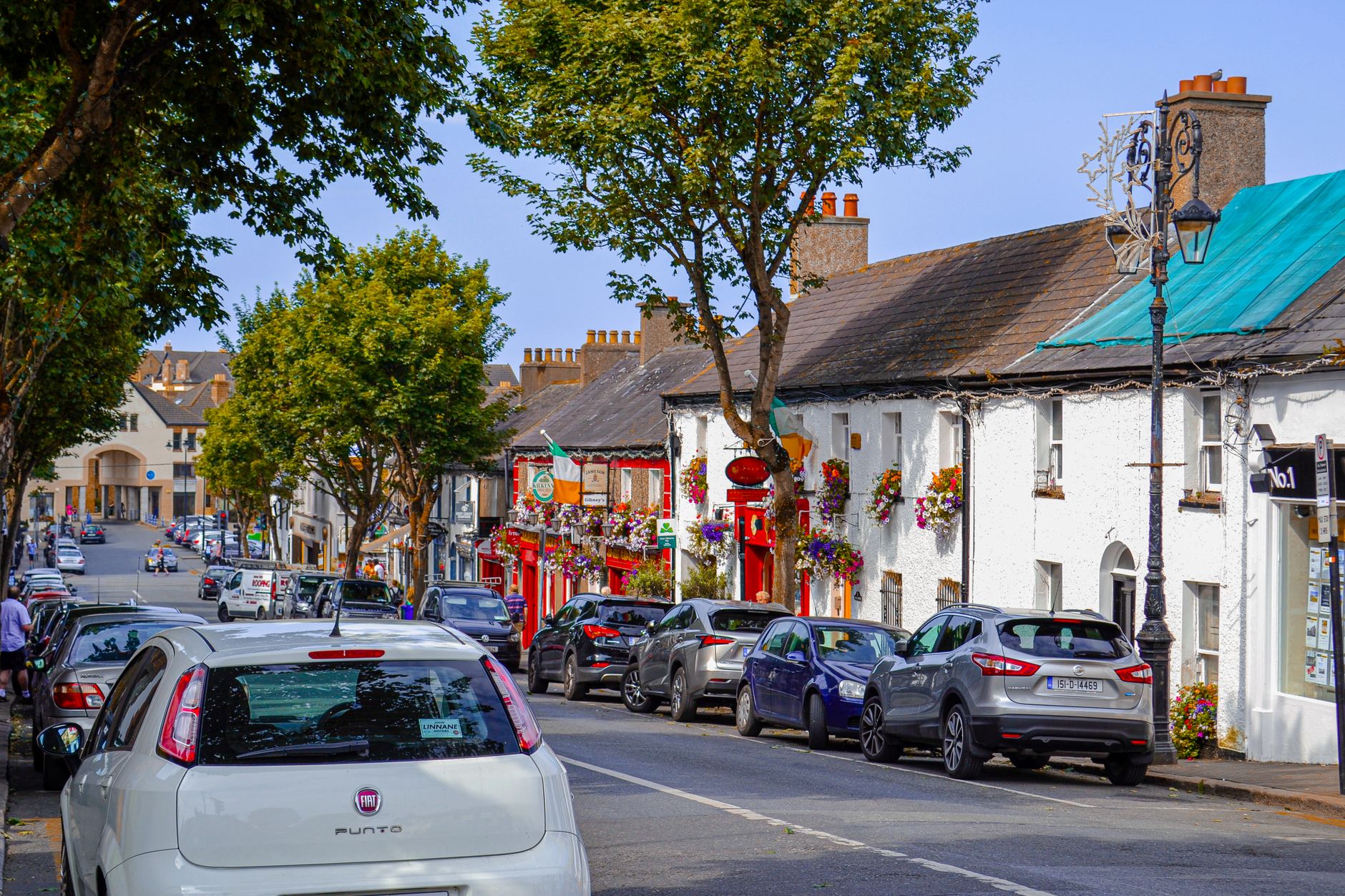 The main street of a coastal village in County Dublin with shopfronts and a tower house