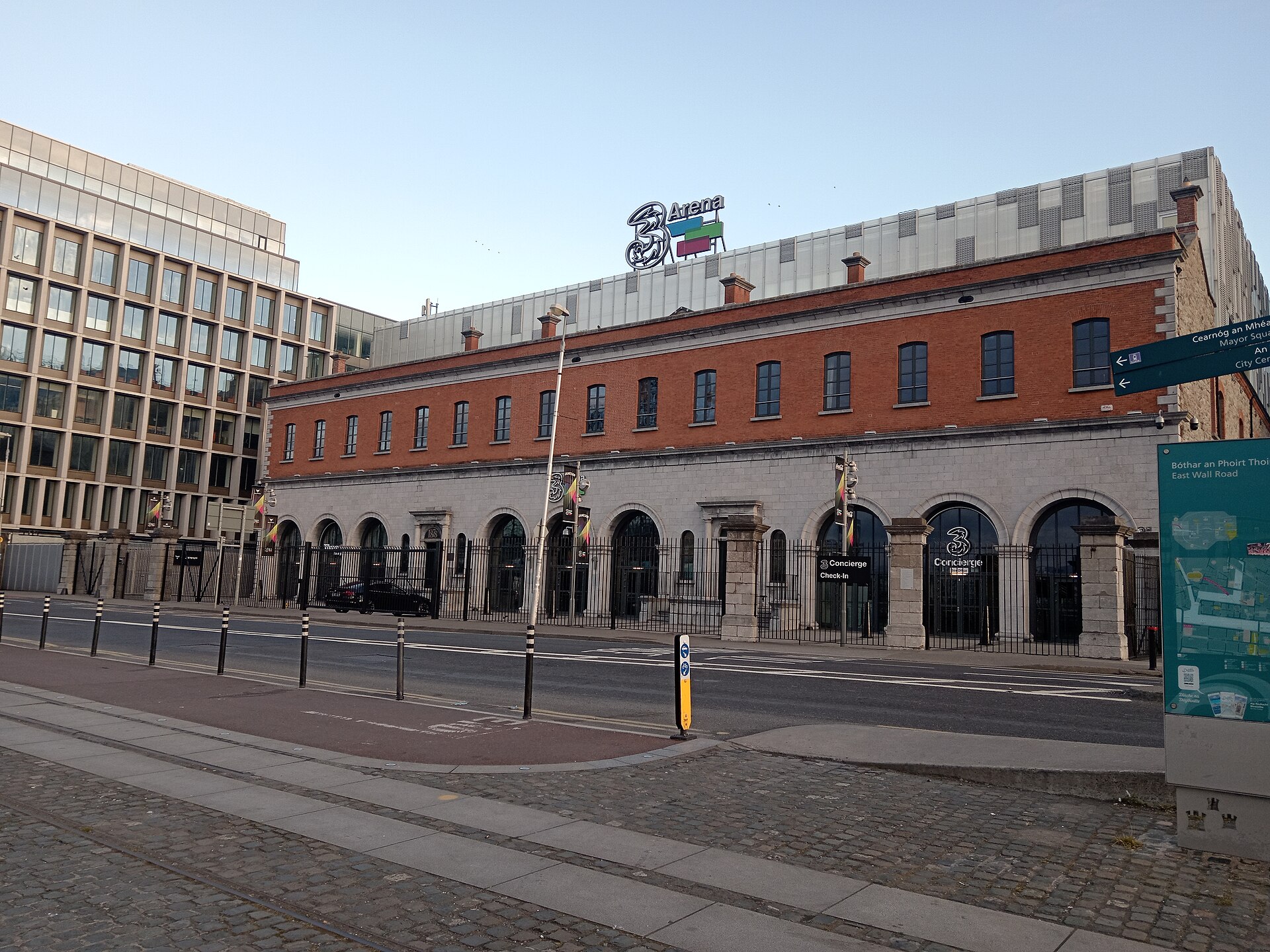 The 3Arena in Dublin has a long red brick facade, arched entrance bays and a large sign above the roof.