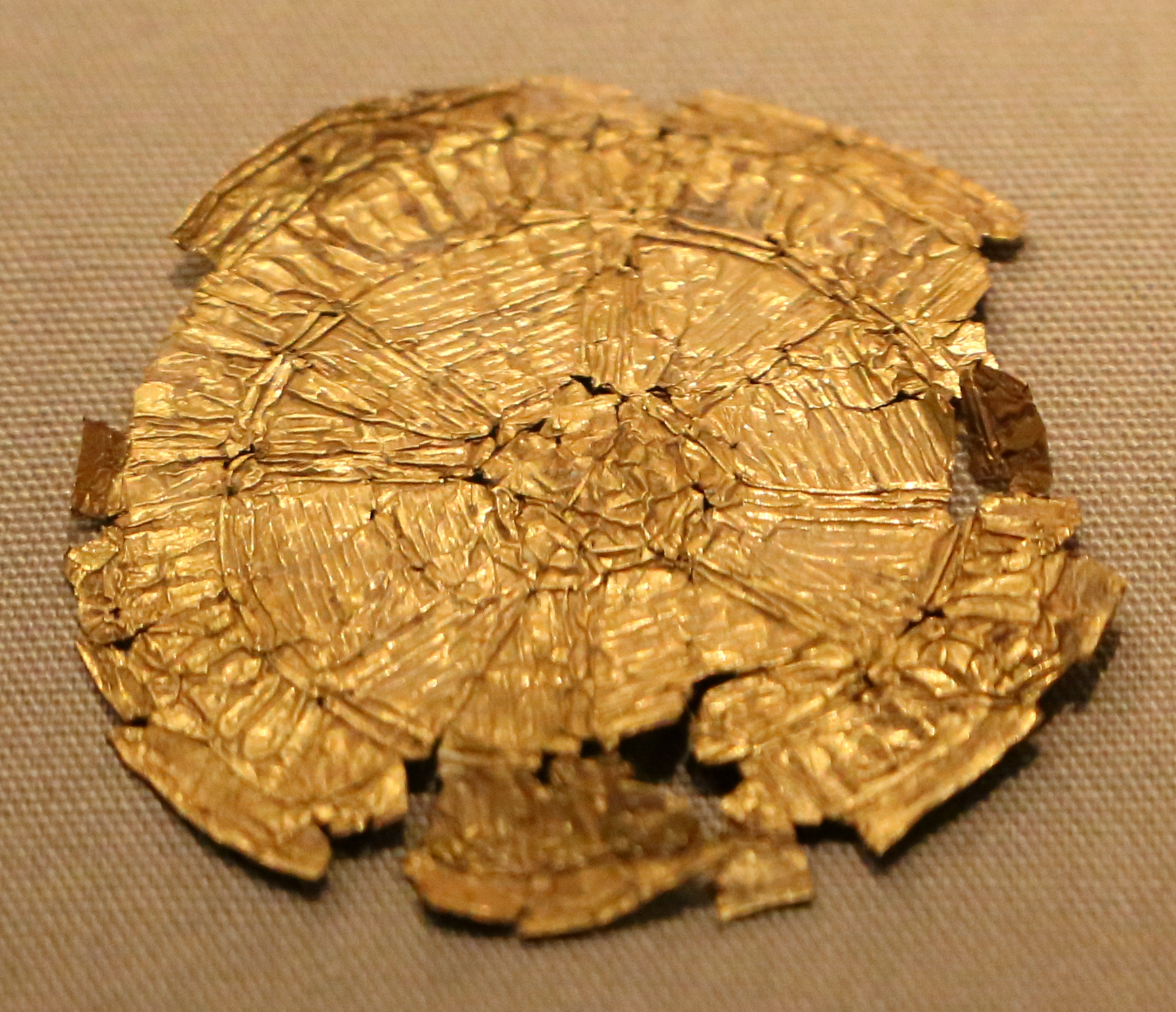A circular gold foil ornament with fine geometric decoration lies in the National Museum of Ireland, Dublin.