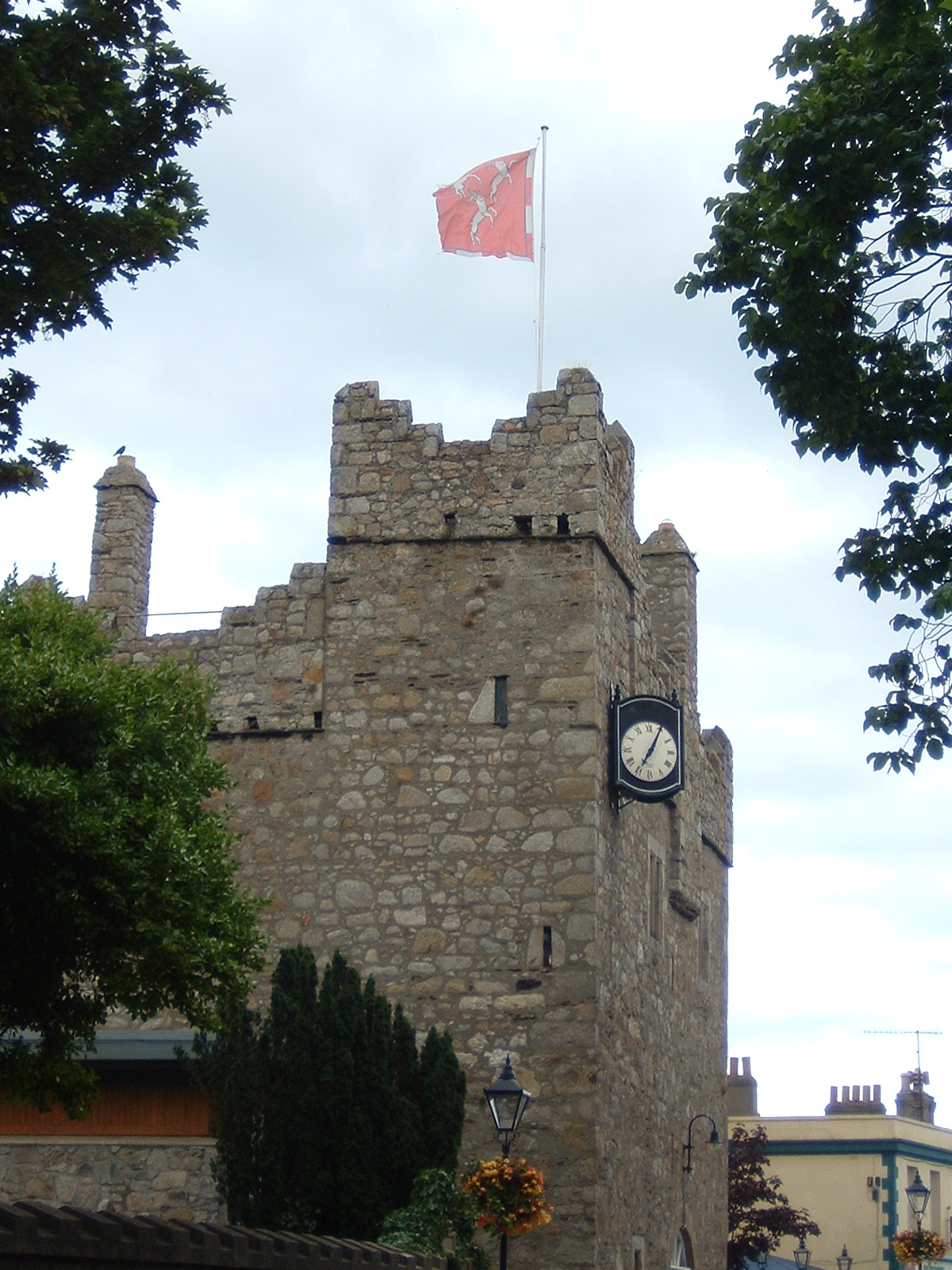 Dalkey Castle rises above the street with stone crenellations, narrow windows, a projecting clock and a flag on the roof.