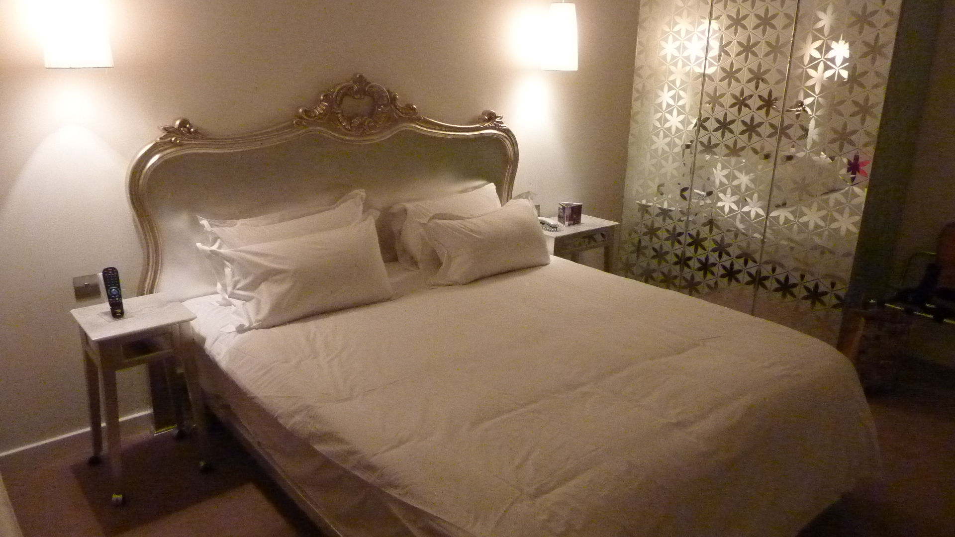 A double bed with an ornate silver headboard and bedside lamps at The Morgan Hotel in Dublin.