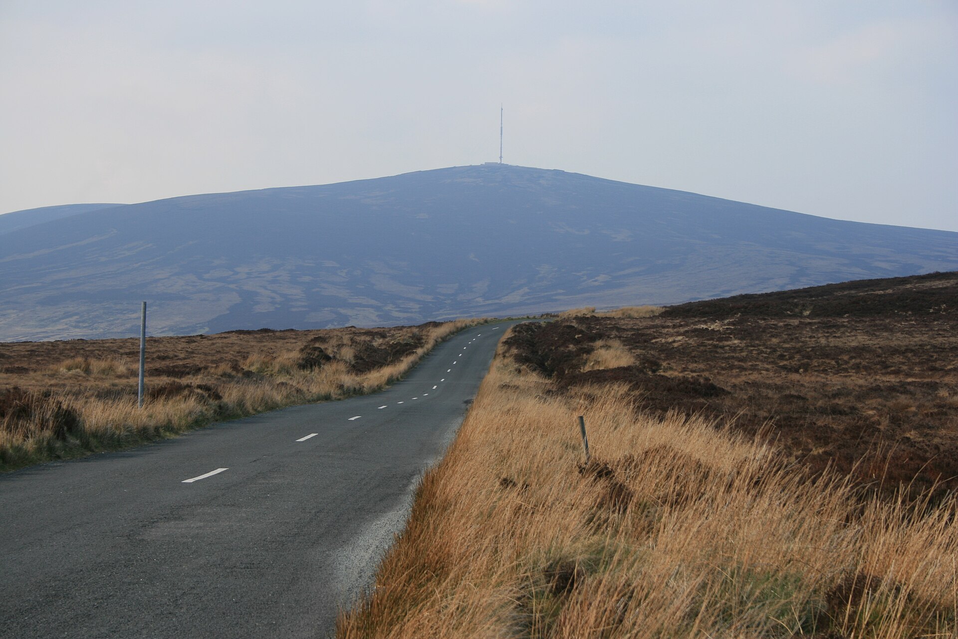 An empty road crosses open moorland at Sally Gap in Wicklow, with Kippure and its mast ahead.