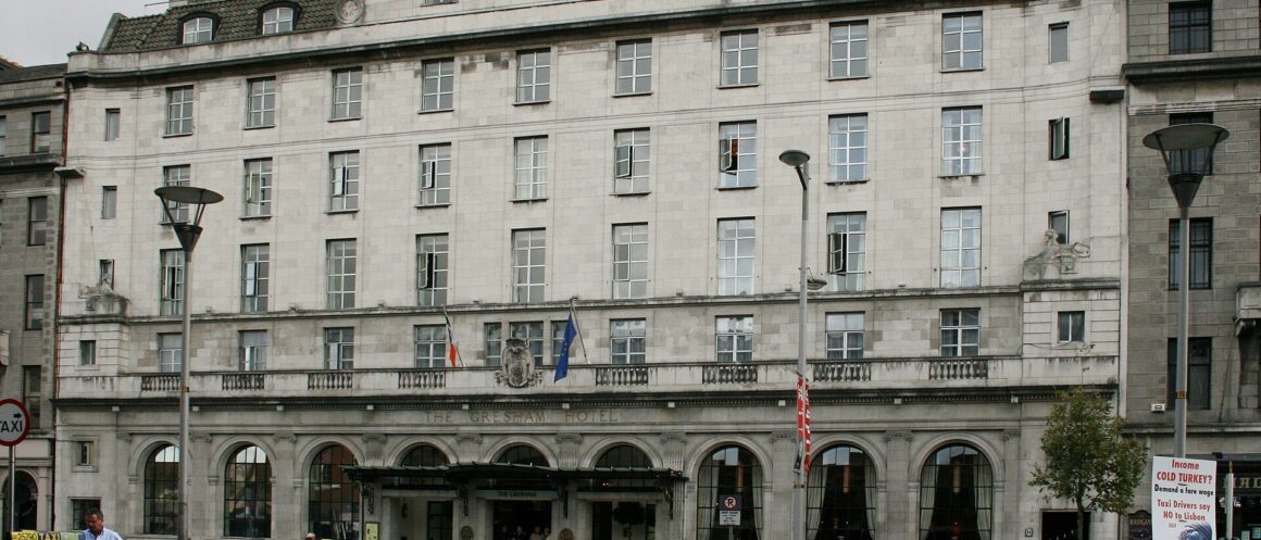 The Gresham Hotel in Dublin has a pale stone facade, arched ground-floor windows and taxis outside its entrance.