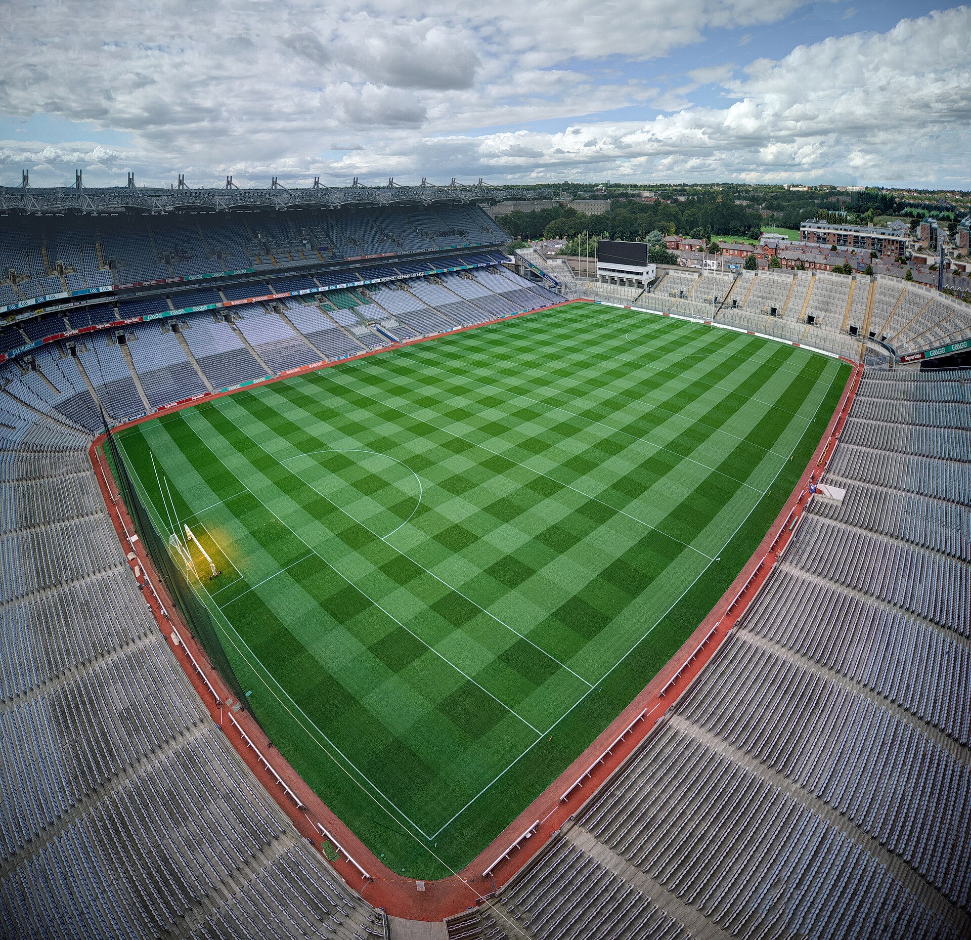 A high corner view across Croke Park shows its striped pitch, empty stands and surrounding Dublin rooftops.