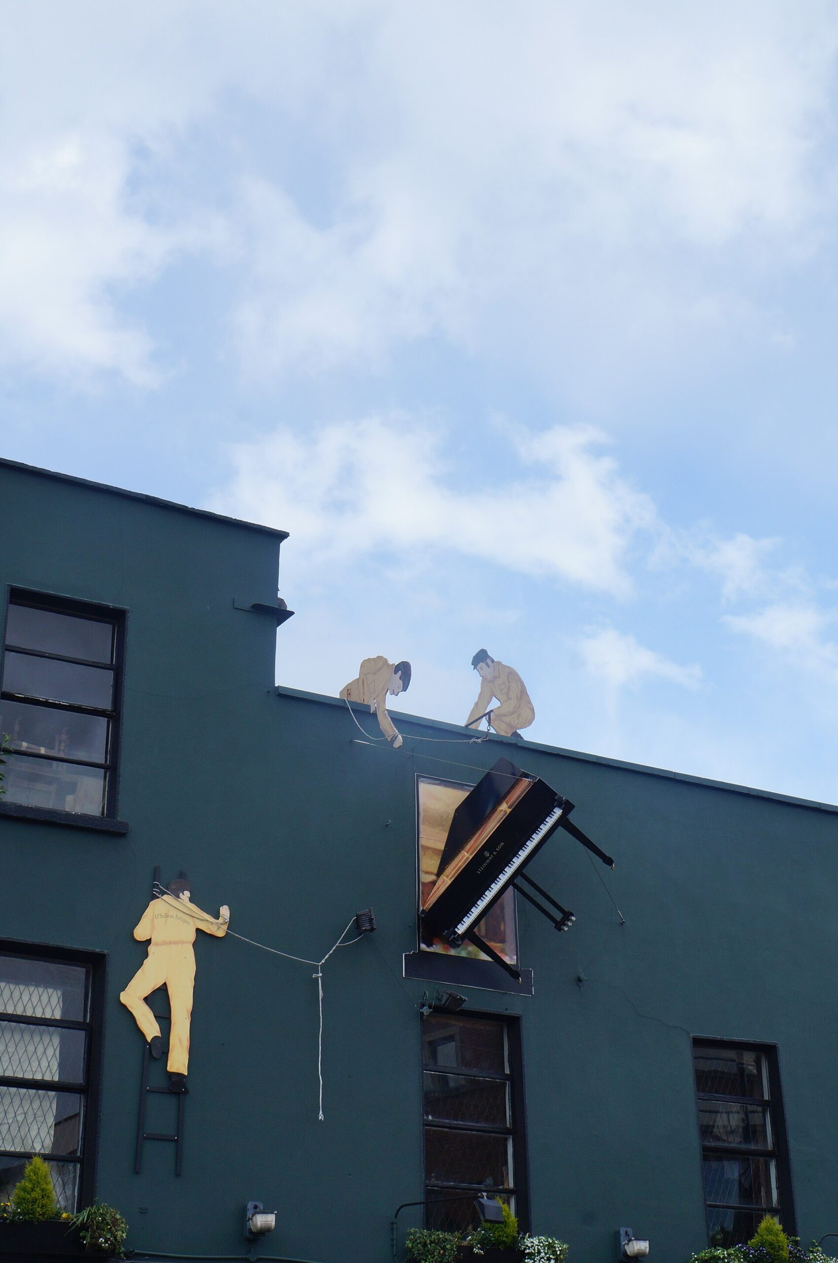 A piano and golden figures decorate the dark green exterior of O'Sullivan Antiques on Francis Street in Dublin.