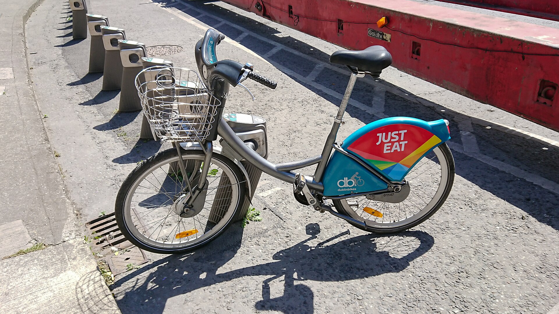 A silver DublinBikes bicycle with a blue rear wheel cover and wire basket at the Guinness Storehouse in Dublin.