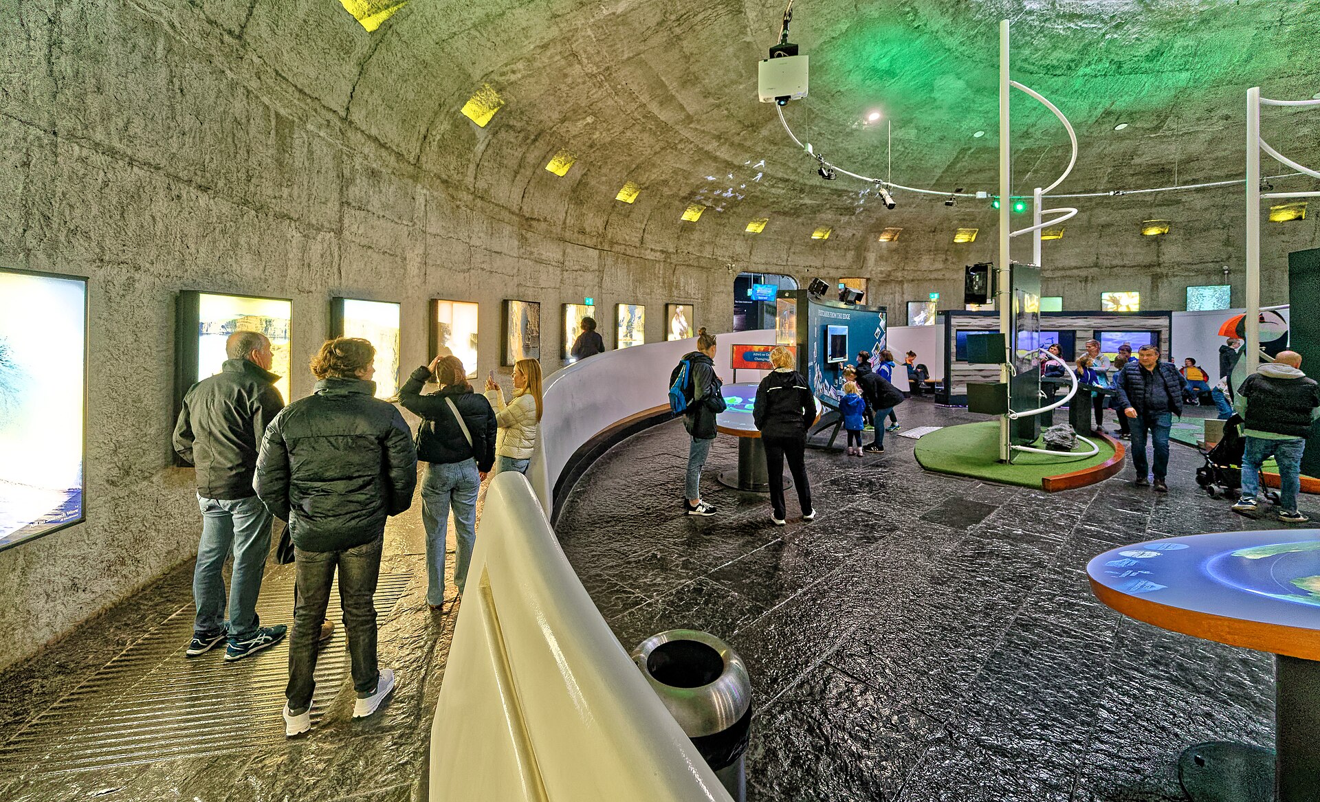 Visitors explore illuminated exhibits beneath the curved ceiling inside the Cliffs of Moher Visitor Experience.
